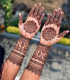 two hands with henna tattoos on them