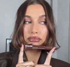 a woman holding up a chocolate bar in front of her face