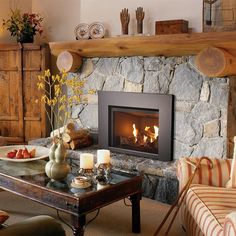 a living room filled with furniture and a fire place next to a stone wall fireplace