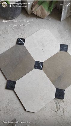 four hexagonal tiles laid out on the floor with black and white marble around them