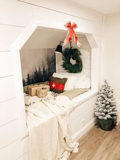 a christmas tree in the corner of a room with a wreath on top of it