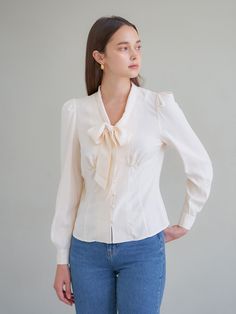 Editor's NotesV-neck blouse with a tied bow and long sleeves. Front opening with fabric button closure.- V-neck- Long sleeve- Bow tie- Button closureMeasurements(in.)Size: One Size (XS-M)- Total Length: 21- Shoulder: 13.3- Chest: 17.3- Waist: 15.5- Armhole: 8.6- Sleeve length: 24.4- Collar height: 2.2*All sizes are based on cross-section.*Errors may occur depending on the measurement method.*The model's arms and legs are long, so the sleeves or the length may appear short. Please refer to the size chart.*Model Info (ELLE): Height 5'9 / Bust 31 / Waist 25 / Hip 35Composition & Care- 62% Modal, 38% Rayon- Dry clean onlyDesigner- by VEM.VER Workwear V-neck Blouse With Tie Sleeves, Elegant V-neck Top With Bow, Tie Neck Blouse With Button Closure For Work, Fitted Office Top With Bow Detail, Fitted Tie Neck Blouse With Button Closure, Fitted Tie Neck Blouse With Tie Sleeves, Fitted Blouse With Tie Sleeves And Tie Neck, Elegant Tie Neck Top With Button Closure, Elegant Tie Neck Tops With Button Closure