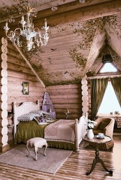 a bedroom with wooden walls and ceiling, chandelier hanging from the rafters