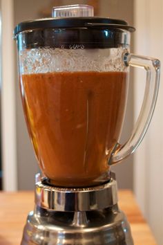 a blender filled with liquid on top of a wooden table