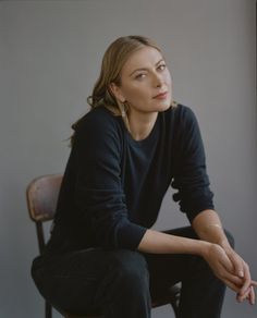 a woman sitting on top of a wooden chair