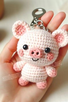 a hand holding a tiny crocheted pig keychain