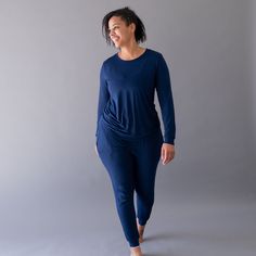 Woman wearing Kyte Baby women's jogger pajama set in Navy Sporty Blue Sleepwear For Loungewear, Stretch Athleisure Sleepwear For Loungewear, Athleisure Stretch Sleepwear For Loungewear, Comfortable Fitted Joggers For Loungewear, Athleisure Crew Neck Sleepwear For Lounging, Fitted Tops With Elastic Waistband For Loungewear, Relaxed Fit Athleisure Sleepwear For Loungewear, Blue Activewear With Ribbed Cuffs For Loungewear, Blue Activewear With Ribbed Cuffs