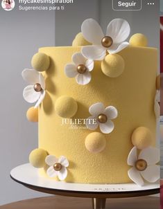 a yellow and white cake with flowers on the top is featured in an instagram