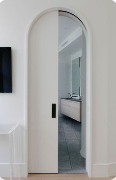 an open door leading into a white bathroom