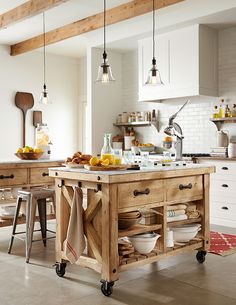 a kitchen island with lots of plates and bowls on it in the middle of a room