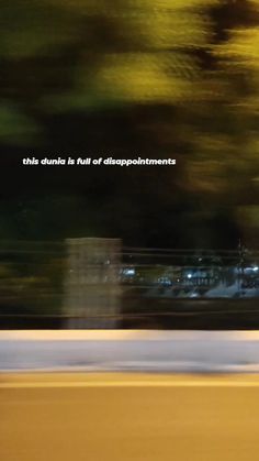 a blurry photo of a person riding a skateboard on the street with trees in the background