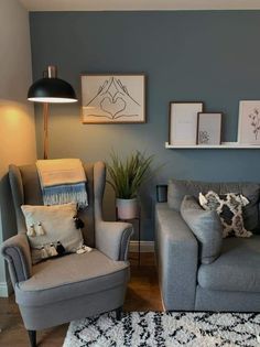 a living room with two gray couches and pictures on the wall above them, along with an area rug