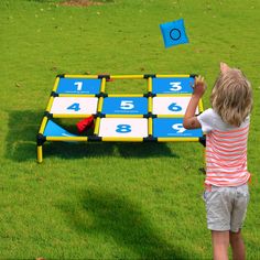 a little boy playing with a giant game set in the grass on top of a field