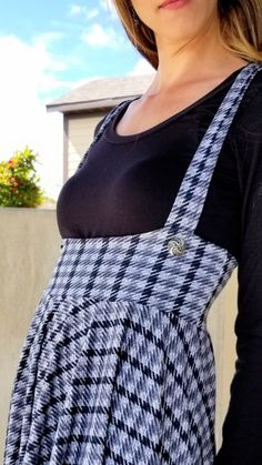 a woman wearing an apron standing in front of a building with her hands on her hips