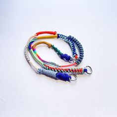 four different colored lanyards on a white surface