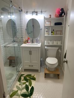 a bathroom with a toilet, sink and shower stall is shown in this image from the doorway