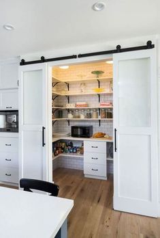 an open kitchen with white cabinets and sliding doors