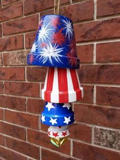 a red, white and blue lamp hanging from a brick wall