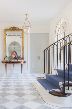 an elegant foyer with marble floors and blue stairs