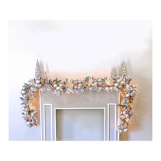 an ornate fireplace mantel decorated with silver and white ornaments on top of the mantle