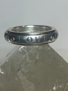 "Hope Faith ring spinner band peace love sterling silver women Size 7.75 Between a size 7.75 and a size 8 Weight 9.1g Width. 3/16\" Free Shipping & Free Postal Insurance Delivered in a Gift Box If you do not want the ring polished and want to leave the natural patina please let me know at the time of purchase as I do polish rings before I ship rings out. Thanks Free First Class shipping and postal insurance is included. If you want to upgrade to priority kindly pay an additional fee to do so. Th Adjustable Hand Stamped Engraved Ring, Adjustable Spiritual Sterling Silver Engraved Ring, Symbolic Stackable Jewelry For Anniversary, Symbolic Adjustable Stackable Rings For Anniversary, Adjustable Engraved Sterling Silver Stackable Rings, Adjustable Sterling Silver Promise Ring, Adjustable Engraved Stackable Rings, Adjustable Stamped Engraved Ring With Round Band, Adjustable Nickel-free Engraved Ring