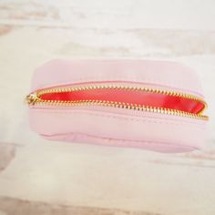 a pink purse with gold zippers on the inside