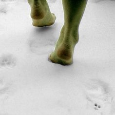 a person walking in the snow with their foot prints on it's side and feet up