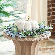 a white pumpkin sitting on top of a planter