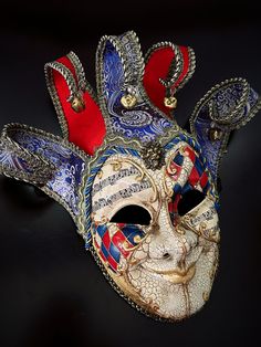 Blue red themed Whimsical and colorful men’s Jester mask is inspired by the traditional Venetian Carnival. This mask features vibrant colors, intricate designs, and exaggerated features to convey a sense of playfulness and jest. Artistic Red Masks And Prosthetics For Theater, Artistic Red Masks And Prosthetics For Costume, Full Face Red Mask For Masquerade, Artistic Red Masks And Prosthetics For Costume Party, Red Full Face Mask For Masquerade, Red Venetian Mask For Masquerade, Traditional Red Masks And Prosthetics For Costume, Traditional Red Costume Masks And Prosthetics, Artistic Red Masks For Costume Party