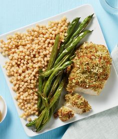 a white plate topped with meat, beans and veggies