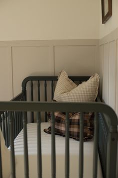 a small crib with a pillow on top of it