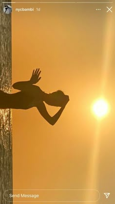 the silhouette of a person standing on top of a beach next to the ocean at sunset