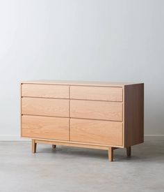 a large wooden dresser sitting on top of a cement floor next to a white wall