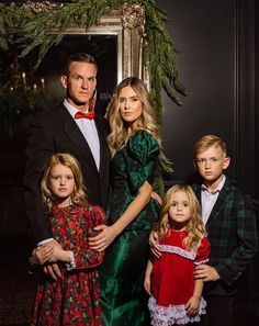 a man and two children standing next to each other in front of a christmas tree