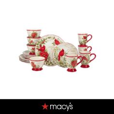 a red and white christmas themed dinnerware set with holly designs on it, including cups and saucers