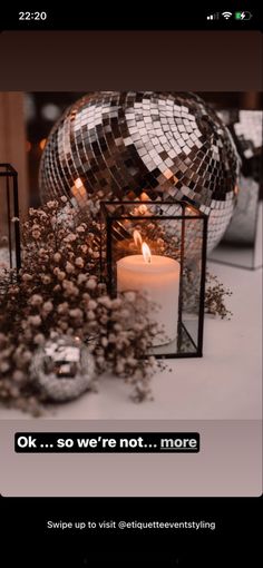 a candle is lit in front of a mirror ball