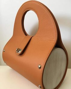 a tan leather purse with an oval handle