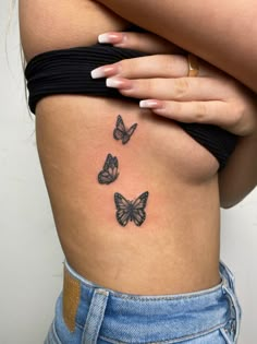 a woman's stomach with three butterflies on her side and the lower part of her body