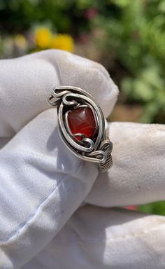 This size 4 ring features a square carnelian spun in antiqued .925 sterling silver. Complimentary polishing cloth included. Red Adjustable Wire Wrapped Rings, Adjustable Red Wire Wrapped Rings, Unique Silver Carnelian Rings, Adjustable Silver Carnelian Rings, Handmade Carnelian Amber Rings, Handmade Amber Carnelian Rings, Wire Wrapped Ring, Sterling Silver Wire Wrap, Wire Wrapped Rings