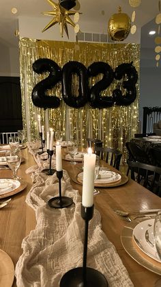 a table set with candles, plates and napkins for a new year's eve celebration