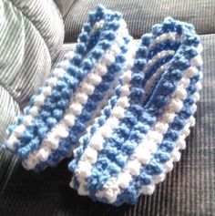 two blue and white crocheted ties sitting on top of a couch