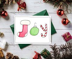 a christmas card with an ornament and candy canes next to holiday decorations