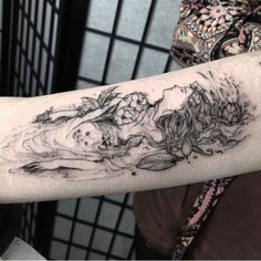 a woman's arm with a tattoo on it that has an image of two women