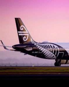 an air new zealand plane taking off from the runway at dusk with purple skies in the background