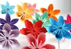 several colorful paper flowers sitting on top of each other