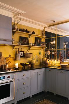 a kitchen with yellow walls and white cabinets