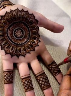 someone is doing henna on their hand