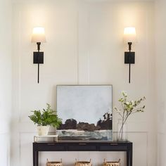 a black console table with two lamps on it