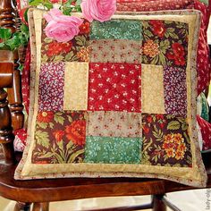 a pillow with flowers on it sitting on a chair