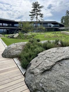 a large rock sitting on top of a wooden walkway next to a lush green field